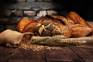 Different kinds of bread and bread rolls on wooden table