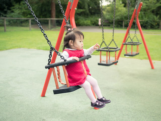 baby girl playing swing  at the playground