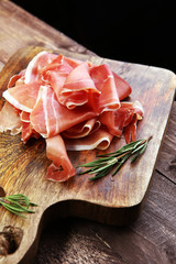 Italian prosciutto crudo or jamon with rosemary. Raw ham.