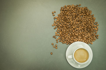Café delicioso, xícara branca de café expresso com grãos de café inteiros em mesa cinza, visto...
