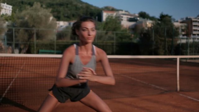 Young woman practicing before a tennis match in the open court.