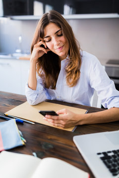 Woman checking the phone wile studying