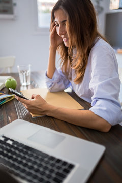 Woman checking the phone wile studying