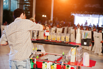 Skillful bartender performing bar tricks in front of a big audience on the wedding.
