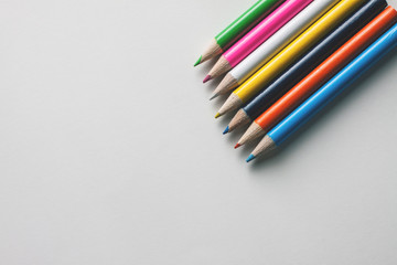 Close-up of a group of multicolored pencils on a white surface