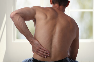 Fototapeta na wymiar Sport injury, Man with back pain. Pain relief and health care concept.