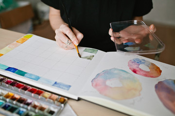 Closeup of hands of artist mixing watercolor