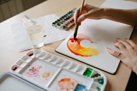 Girl artist paints watercolors color wheel