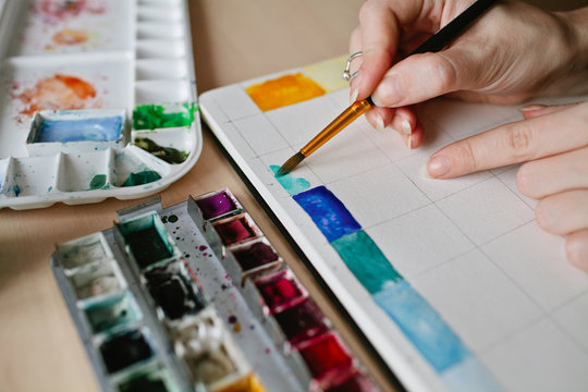 Closeup of hands of artist mixing watercolor