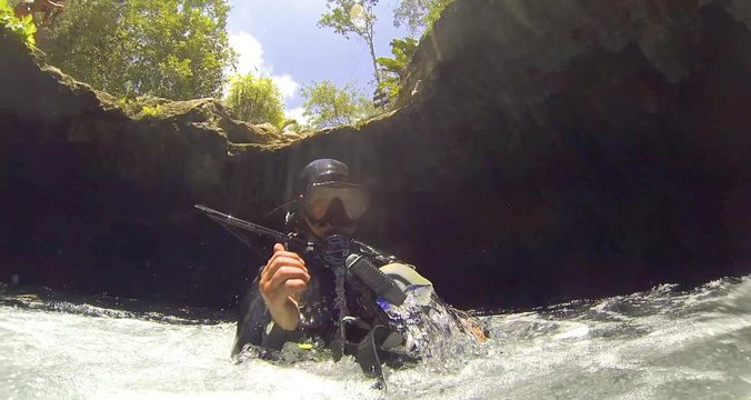Прыгающий дайвер в воду пещеры. Пещерный дайвинг в сенотах, Ривьера Майя, Мексика 