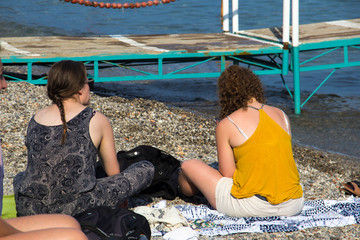 Duas garotas conversando na praia. 