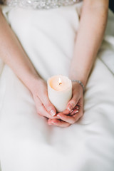 Wedding candle in hands of the bride