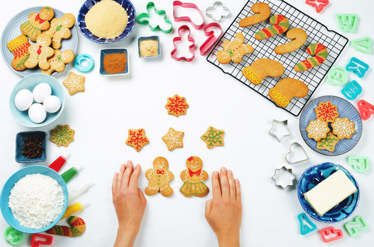 Gingerbread cookies with ingredients for baking and woman's hands