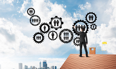 Businessman on house roof presenting teamwork and connection concept. Mixed media