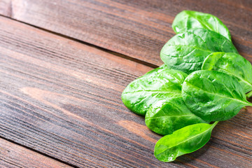 Green fresh spinach leaves on a wooden table