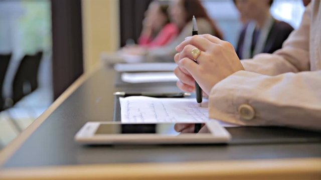 Person hold pen over written notes at conference close up