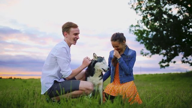 family, pet, animal and people concept - happy couple with labrador retriever dog walking in city park