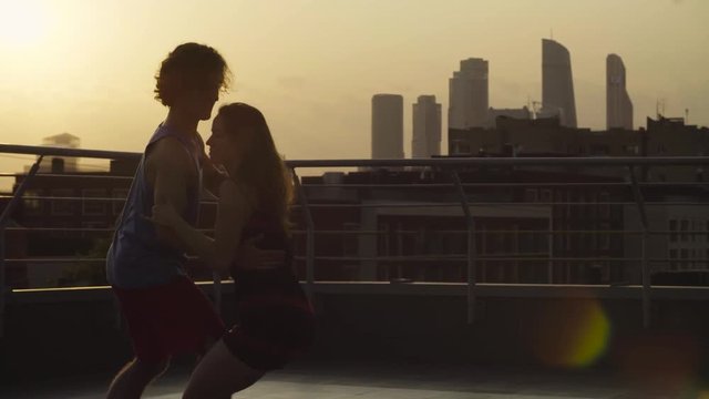 Silhouettes of young couple dancing on sunset