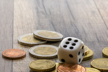 Dice and coins stack on wooden table