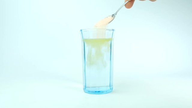 Fruit Salt (Effervescent powder) dissolving in a glass of water.