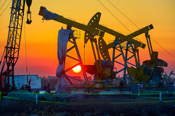The oil derrick of oil field sunset