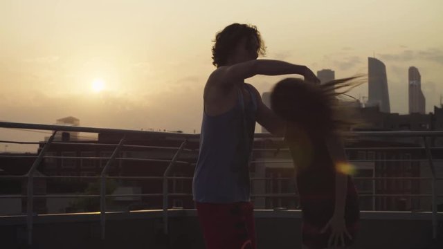 Young couple dancing on sunset