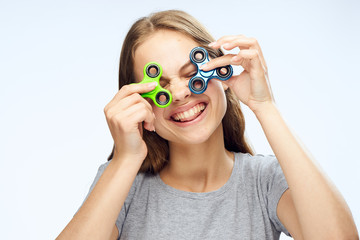 Beautiful young woman on white isolated background holds spinners
