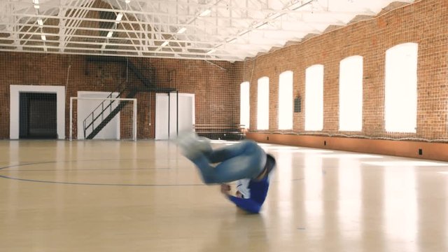 Male breakdancer dancing in sport gym