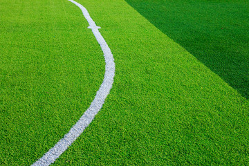 Photo of a green synthetic grass sports field with white line shot from above