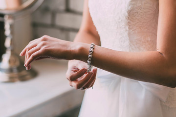 Bride fastens a bracelet. Wedding concept. Artwork. Soft focus on a hand - 168819085