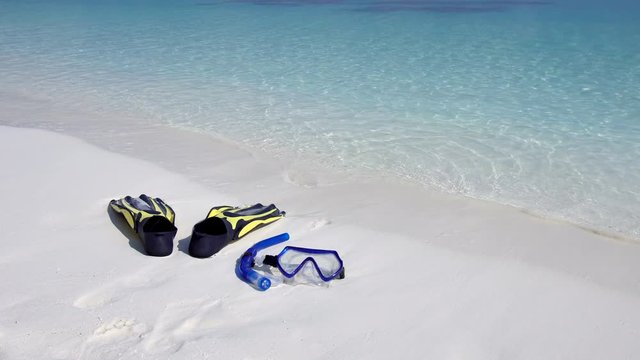 Swimming mask, fins and tube on white sandy seashore. Tropical vacation on beach. Nobody