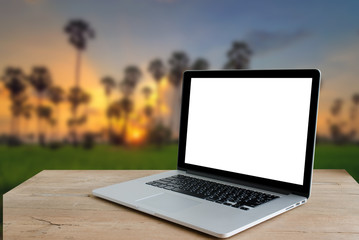 workspace with modern laptop at sunset