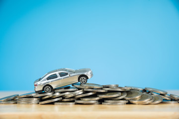 miniature car model on stack of coins