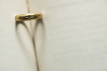 gold ring with shadow heart shape on the book page