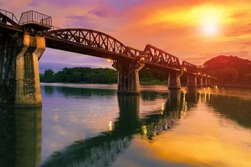 Foto op Plexiglas colorful twilight time of river khaw bridge in kanchanaburi most popular world war II history traveling destination in western of thailand © stockphoto mania