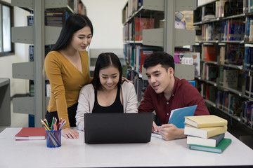 Group of college students studying using laptop in the school library, Education concept.