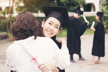 Young female graduate hugging her mother at graduation ceremony, Success,Goal. Education concept.