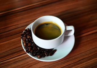 Hot American Coffee In a glass on a brown wood floor.