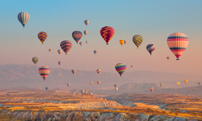 Hot air balloon flying over spectacular Cappadocia - obrazy, fototapety, plakaty