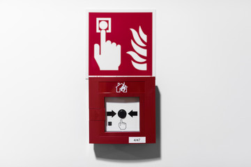 Red Fire alarm button on white wall 