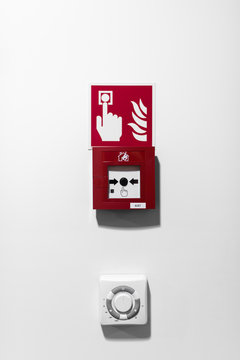 Red Fire alarm button on white wall 