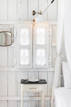 interior of light modern wooden house inside, vintage window with shutters and decorative curtains. Rustic and village style