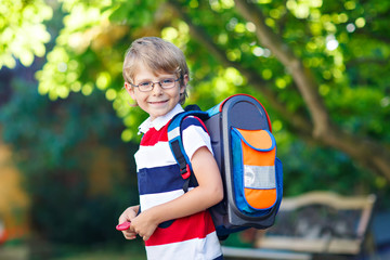 little kid boy with school satchel on first day to school