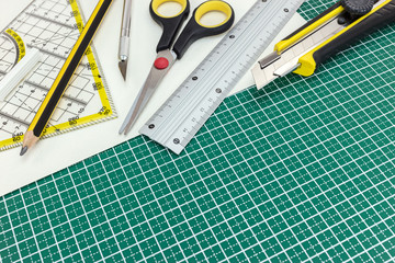 school and office various supplies on green cutting mat. working desk.