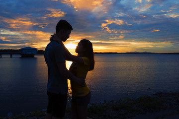 Fototapeta premium Silhouette couple in love at lake during beautiful sunset.