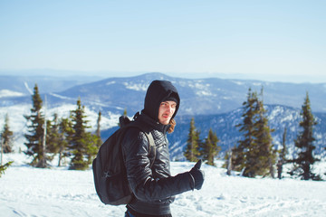 Fototapeta na wymiar The guy is standing in the mountains in winter