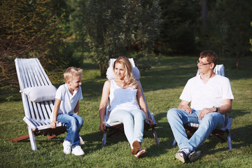 Happy family enjoying in the Park the sun lounger.