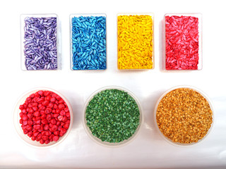 Many melon, chili and corn seeds coating by colors in plastic boxes