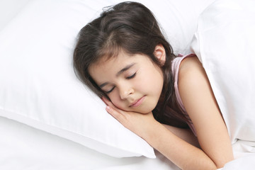 Beautiful little girl sleeping in white bed