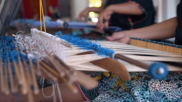 Close up of woman hand weaving with sticks, making traditional sarong in Sukarara Village, Lombok, Indonesia. Shot with Sony a7s and Atomos Ninja Flame.